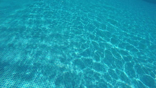 SLOW MOTION: Man swimmer diving underwater in hotel swimming pool PoV