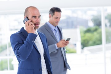 Business colleagues using phones
