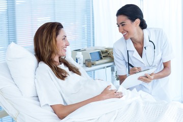 Fototapeta premium Smiling pregnant woman with her doctor