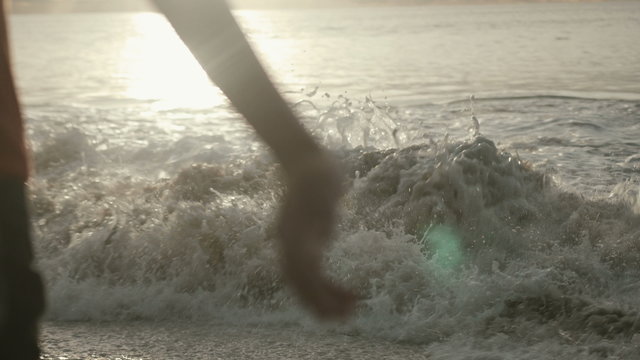 Close up of female arms under the sunrise at seaside. Happy woman enjoying sunset. Woman embracing the golden sunshine glow of sunset with arms outspread enjoying peace, serenity in nature.