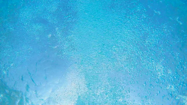 SLOW MOTION: Man swimming in hotel pool underwater shot 
