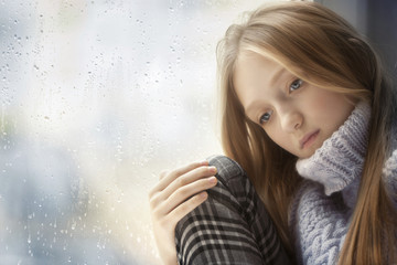 Rainy Day: sad Girl on the Window