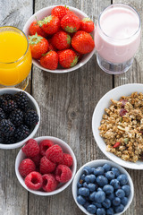 healthy breakfast with berries on wooden background, top view