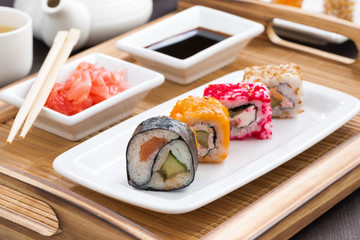 Japanese meal - sushi and rolls on white plate