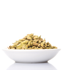 Cardamom spices in white bowl over white background