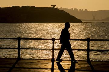 Hombre caminando al atardecer por la ciudad
