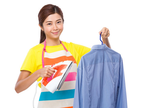 Asian Housewife using the steam iron on shirt