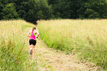 two girls running a race in the meadow