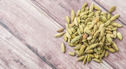 Cardamom spice over weathered wood background