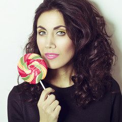 Portrait of beautiful young woman with lollipop