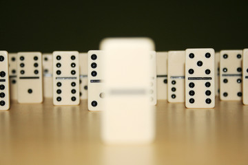 Close up picture of dominos, one from the crowd