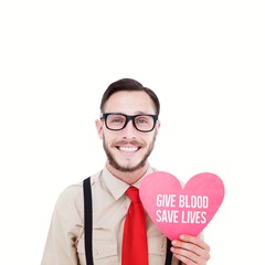 Composite image of geeky hipster smiling and holding heart card