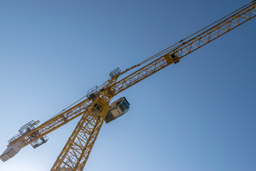 Tower crane on blue sky background.