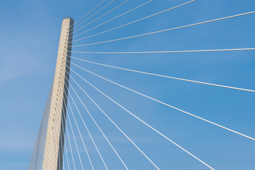 Fragment of a modern cable stayed bridge on the sky background.