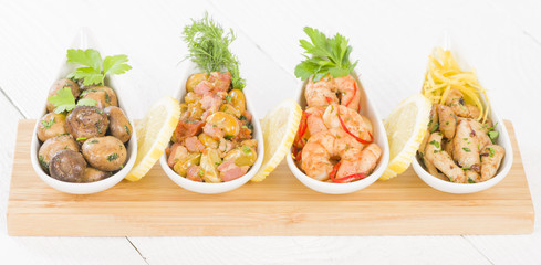 Spanish Tapas - Setas al Ajillo (sauteed mushrooms with garlic), Gambas Pil Pil (sizzling prawns), Pollo al limon con ajo (chicken with garlic) and Habas Con Chorizo (broad beans with chorizo).
