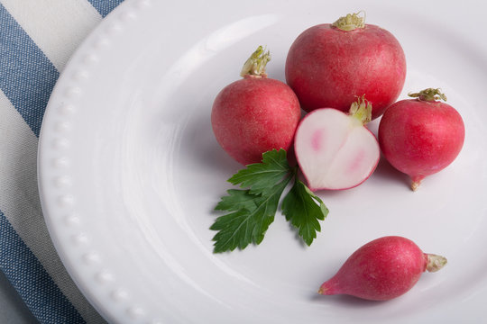 Five radishes on a whote plate