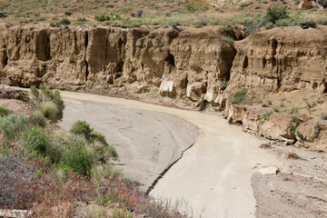Close up of arroyo cutting through the desert in New Mexico with water running through it