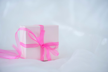 Gift box with ribbon on cloth background