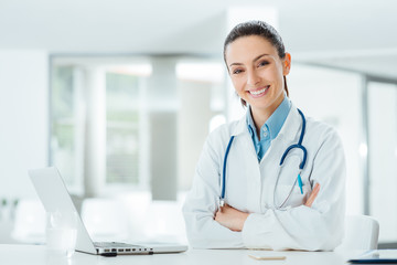 Confident female doctor at office desk