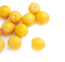 Pile of multiple yellow plums isolated