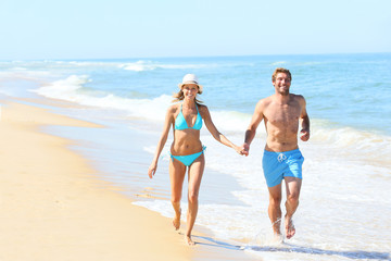 Couple having fun running on the beach