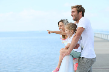 Family standing on a pontoon looking at the sea