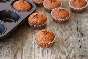 Obraz na płótnie Canvas delicious homemade muffins over wooden board selective focus