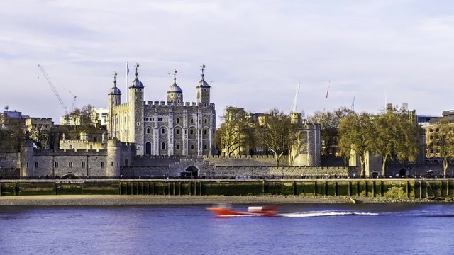 Time lapse of the Tower of London viewed from South bank with boats passing by on a late afternoon in spring. The oldest building in London