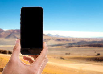 Phone with black screen with desert background