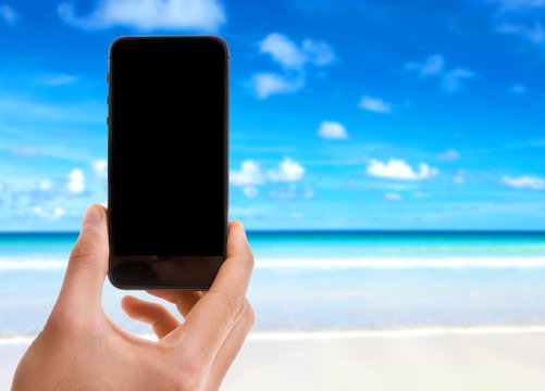 Phone with black screen on beach background