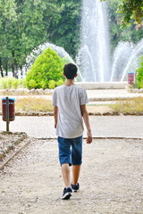 ragazzo passeggia in un giardino pubblico