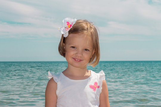 Adorable little girl plays on the beach.