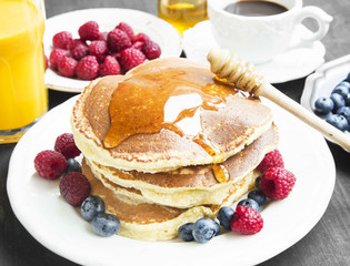 Breakfast Pancakes with Honey Flowing,Coffee and Berries