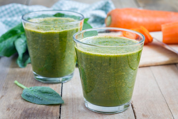Healthy green spinach carrot smoothie in a glass - obrazy, fototapety, plakaty