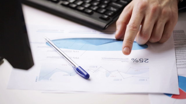 close up of male hands with charts and keyboard
