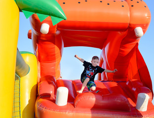 Young boy jumping on a plastic jumping castle