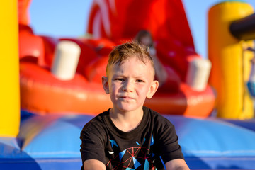 Fototapeta na wymiar Thoughtful little boy in a kids playground