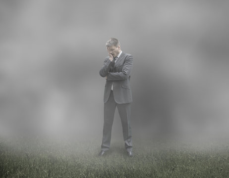 Sad and Tired Businessman in Misty Cloudy Background