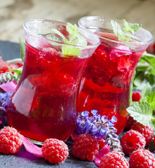 Hot red tea with raspberries, mint and rose petals, selective fo