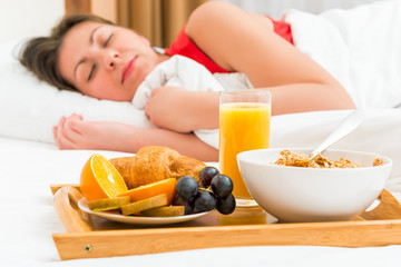 Obraz na płótnie Canvas healthy breakfast in focus and sleeping girl