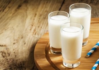 Fresh peasant milk jug and glasses on  wooden table, selective f