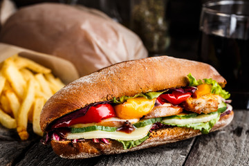 Chicken sandwich, fries and glass of soda