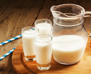 Fresh peasant milk jug and glasses on  wooden table, selective f