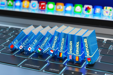 Foreign languages learn and translate education concept, books with flags of world countries on computer laptop keyboard