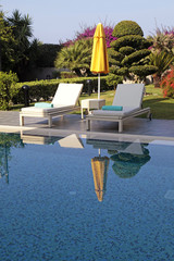 białe leżaki w basenie do relaksu w piękne lato - 86215196