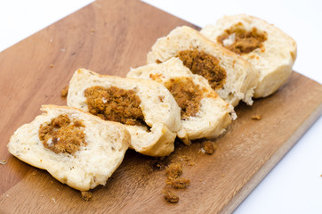 dried shredded pork bread on cutting board on a white background