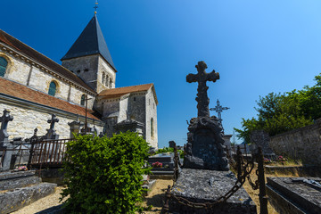 Fototapeta na wymiar Medieval ,stony church in French village with old cemetery .