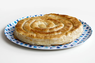 Cheese pie. Homemade balkan burek in a plate. Image isolated on white.