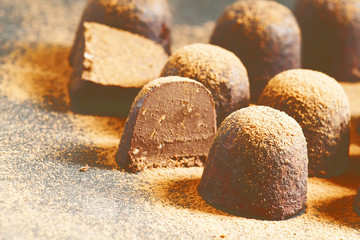 Homemade chocolate truffles with cocoa powder on dark background