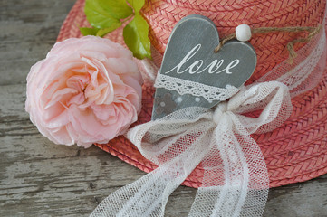 Heart, rose, hat on wooden background